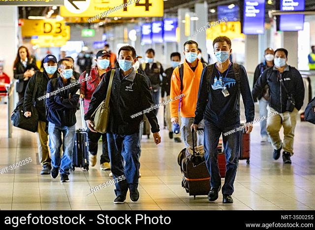 SCHIPHOL - A group passengers just arrived with a flight from Kuala Lumpur ar Schiphol Airport. Closed gates and departure halls at Schiphol during times of the...