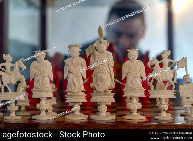 21 January 2023, Saxony-Anhalt, Löberitz: Oliver Lindner, volunteer at the Löberitz Chess Museum, looks at an ivory chess set through a glass display case