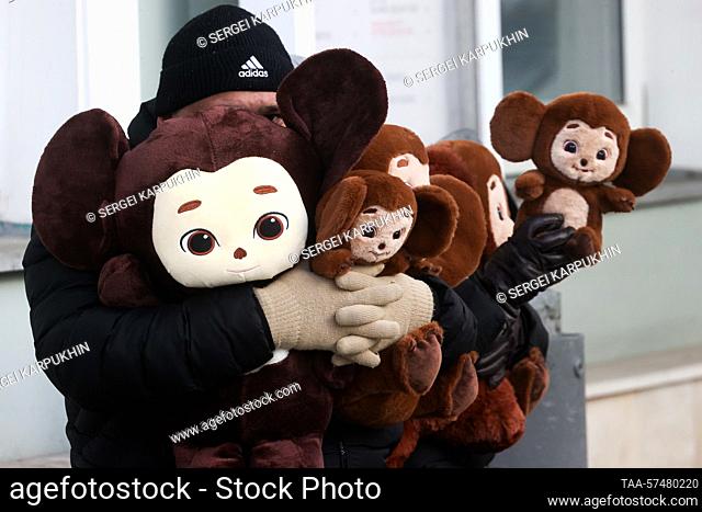 RUSSIA, MOSCOW - FEBRUARY 21, 2023: A man holds an armful of Cheburashka stuffed toys. Sergei Karpukhin/TASS