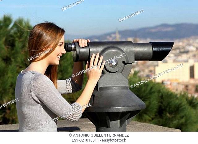 Tourist woman watching city through a telescope