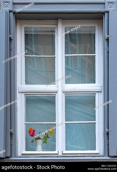 Germany, Saxony-Anhalt, Quedlinburg, flowers stand in a window of a half-timbered house