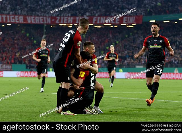 19 April 2022, Hamburg: Soccer: DFB Cup, Hamburger SV - SC Freiburg, semifinal, Volksparkstadion. Freiburg's Nicolas Höfler (bottom center) celebrates after...