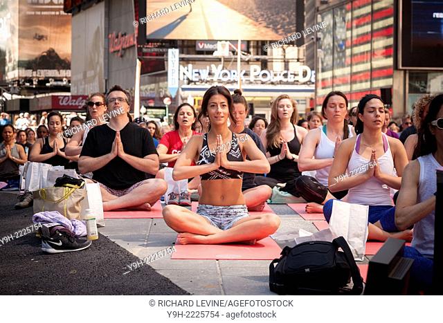 Thousands of yoga practitioners pack Times Square in New York to participate in a Power Yoga class on the first day of summer