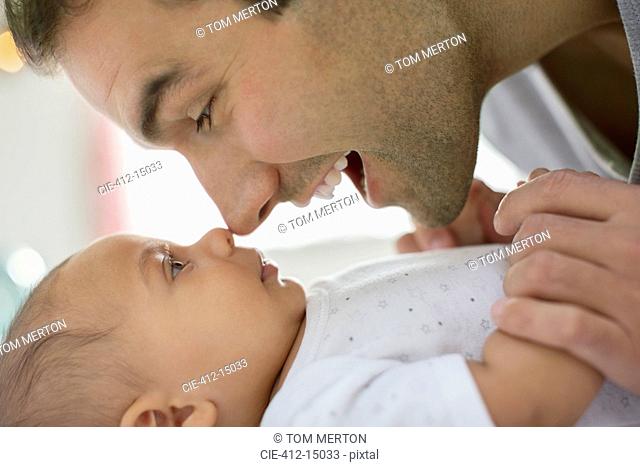 Father rubbing noses with baby boy