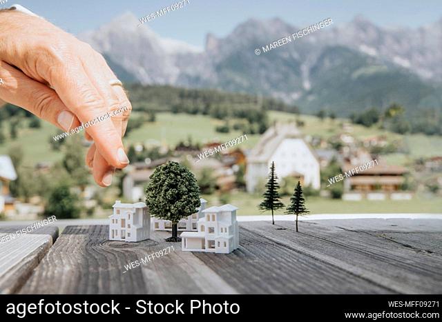 Hand of engineer pointing at building models on table
