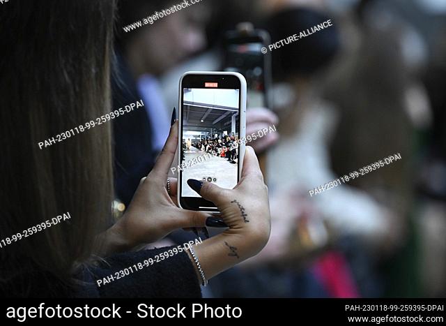17 January 2023, Berlin: Young women hold their smartphones and film a fashion show at Berlin Fashion Week. Berlin Fashion Week takes place from January 16 to...