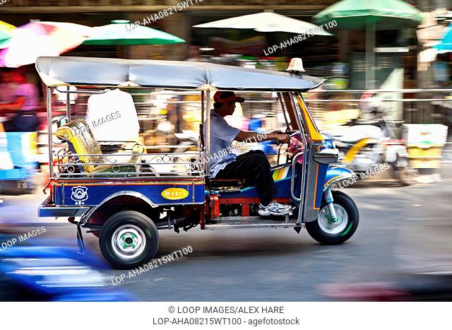 A tuk tuk passing through the busy streets of Bangkok