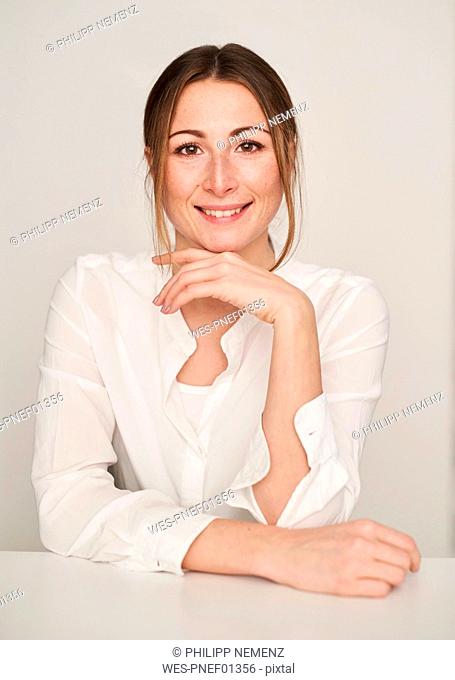 Portrait of smiling young woman wearing white blouse