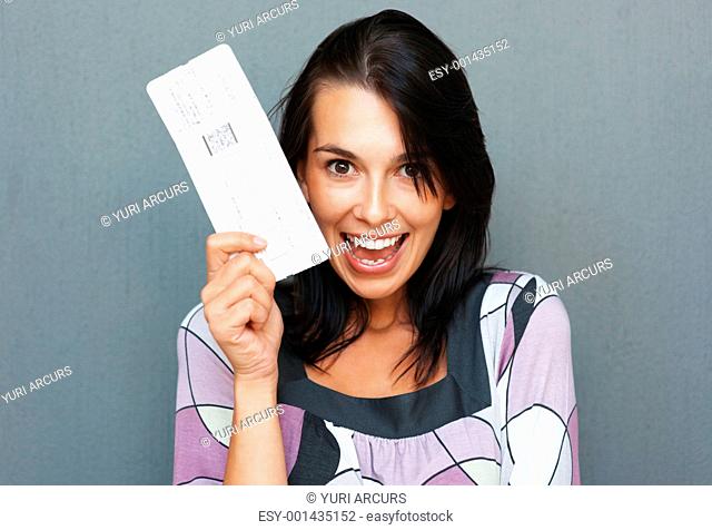 Woman holding up airplane ticket and smiling