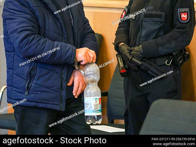 11 December 2023, Lower Saxony, Osnabrück: The 82-year-old defendant arrives in handcuffs for the expected verdict in the Osnabrück district court