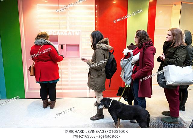 Cupcake lovers flock to the Sprinkles Cupcakes bakery's 24-hour cupcake ATM in New York on its grand opening day. The automated dispenser is located next to the...