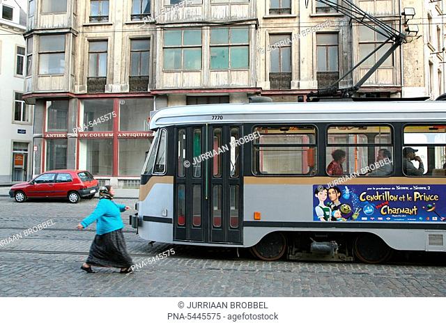 A woman rushing to catch a tram in downtown Brussels, Belgium