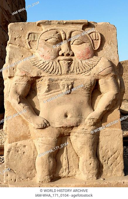 Relief sculpture of the Egyptian God, Bes in the forecourt of the Hathor Temple at Dendera. The dwarf-like god was seen as the protector of pregnant women