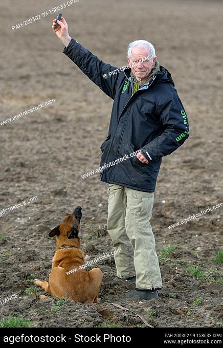 27 February 2020, Brandenburg, Wriezen: Günter Hytra, dog sports friend, with his dog Athos, a so-called Malinois, a variety of the Belgian shepherd dog