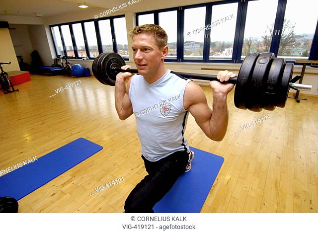 Man is exercising with a dumbbell at at step within a gym  - Geesthacht, Schleswig-Holstein, GERMANY, 06/04/2007