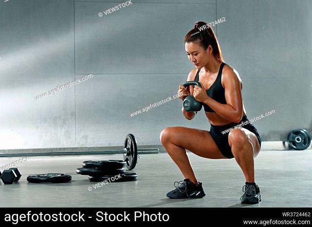 The young woman in the gym for kettle bell