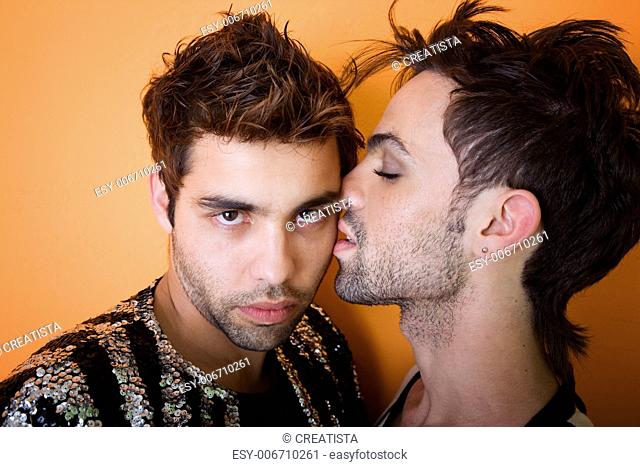 Attractive gay man kissing another on the cheek