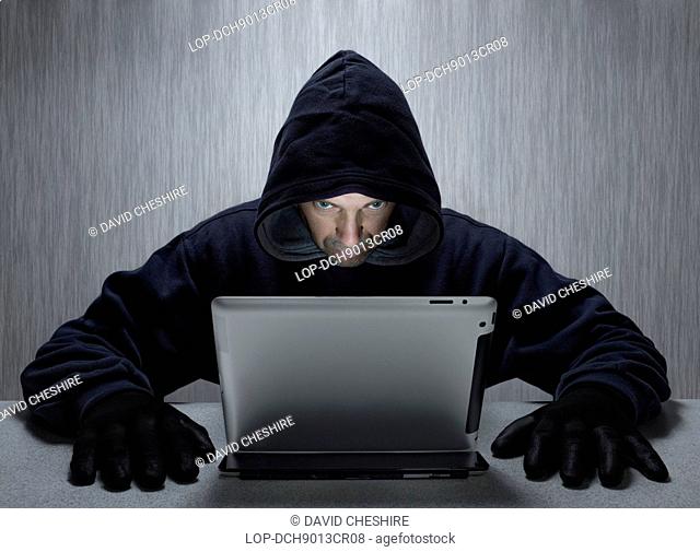 Wales, Monmouthshire, Monmouth. A hooded man representing a cyber criminal