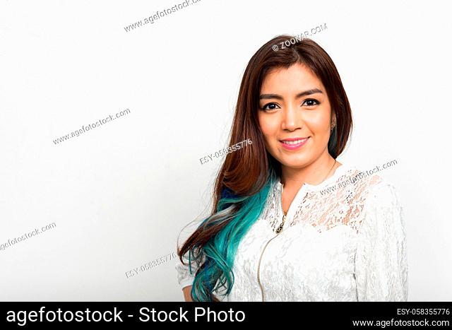 Studio shot of young beautiful Asian woman with dyed hair against white background