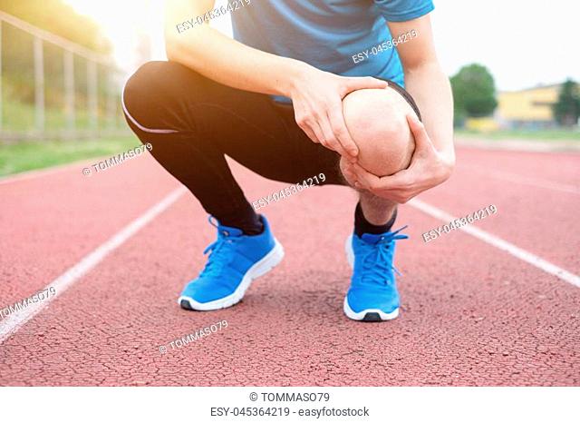 Running athlete feeling pain after having his knee injured