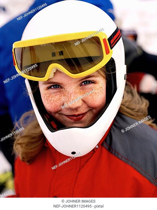 Girl wearing skiwear and goggles smiling, portrait
