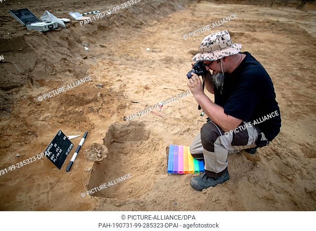 31 July 2019, Mecklenburg-Western Pomerania, Pinnow: Fabian Möller, excavation assistant at the State Office for Archaeology in Mecklenburg-Vorpommern