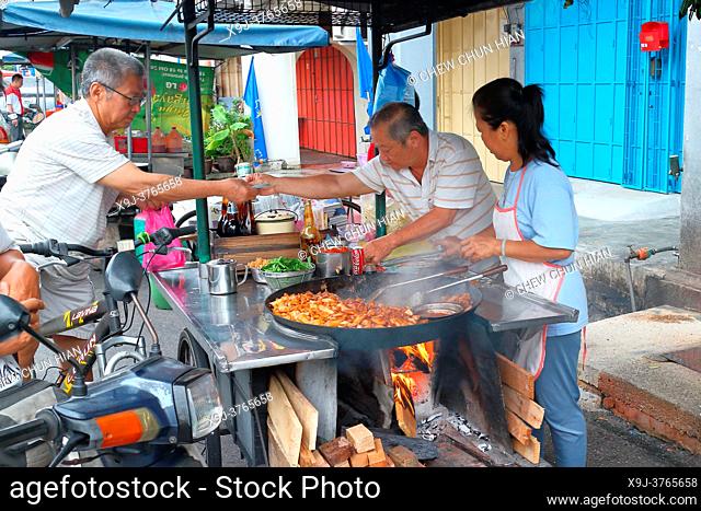 cooking stir fried cha kueh in a wok in Penang, Malaysia