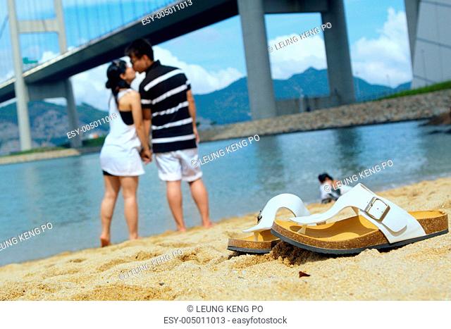 modern couple kissing each other on beach