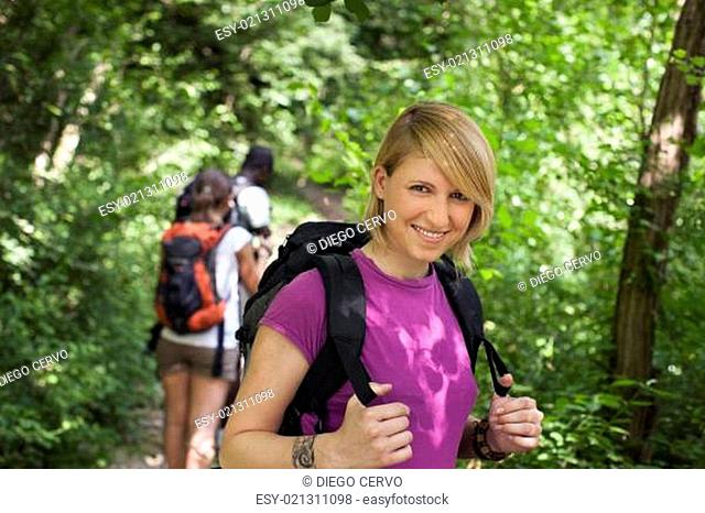 people with backpack doing trekking in wood