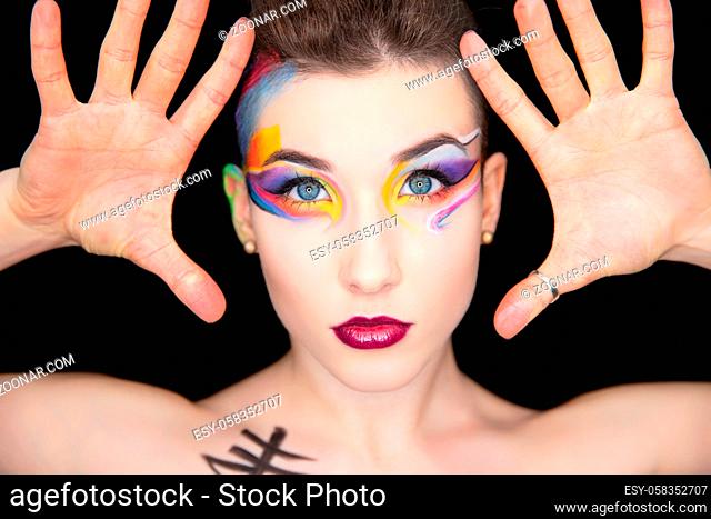 Portrait of a nice young brunette with creative make up and body painting