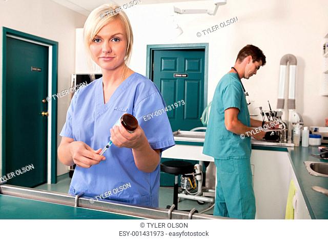 Nurse with syringe while doctor writing report