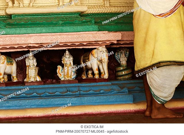 Low section view of a man standing in a temple, Kamakshi Amman Temple, Kanchipuram, Tamil Nadu, India
