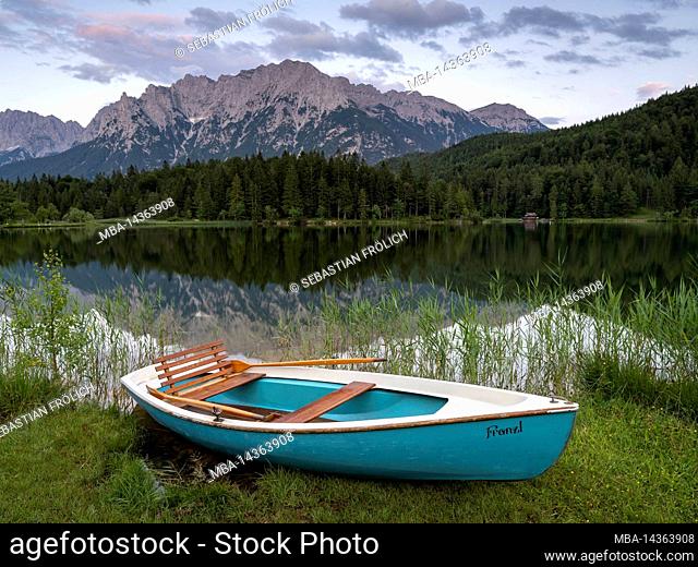 Rowing boat lies on the shore of the small Lautersee near Mittenwald in the Bavarian Alps. In the background the Northern Karwendel and the Western...