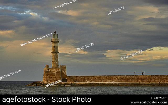 Venetian old town, Venetian harbour, Venetian lighthouse, harbour wall, people on harbour wall, dramatic cloudy sky, Chania, West Crete, island of Crete, Greece