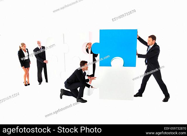 Business teamwork building big puzzle isolated on white background