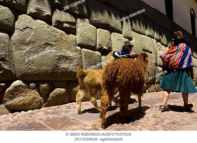 A woman and her llamas beside the stone of 12 angles. This stone is well known, the peculiarity that made her famous is the presence of 12 angles which fits...