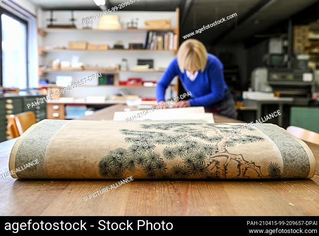 13 April 2021, Berlin: Bookbinder Julia Flögel works on the restoration of a Chinese scroll painting in the paper workshop in Friedrichshagen