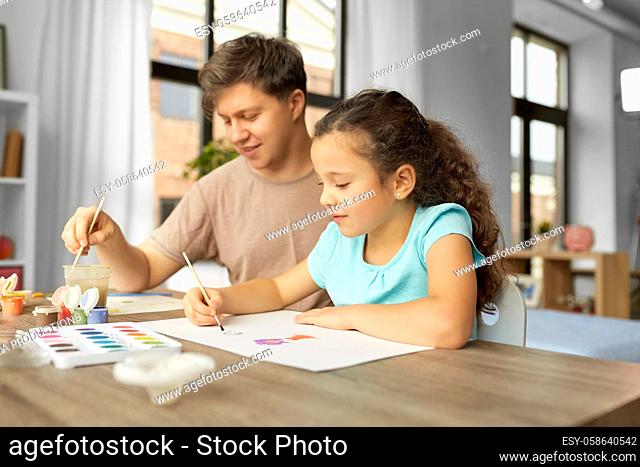 happy father with little daughter drawing at home