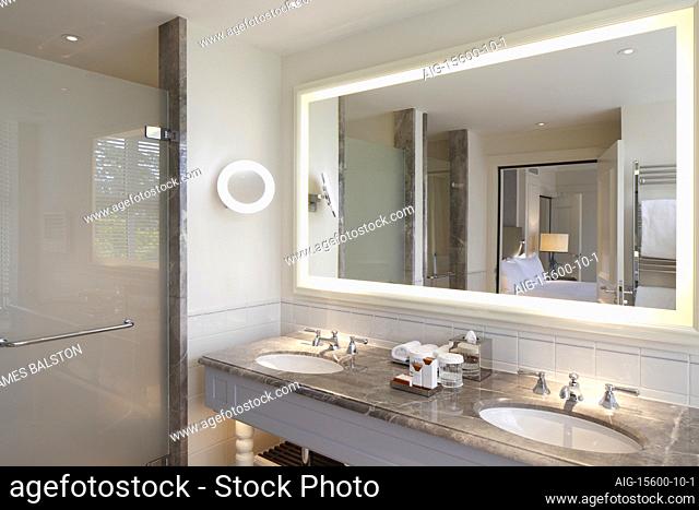 Large framed mirror with integral lighting above the marble topped twin basin vanity unit | | Designer: GA Design International