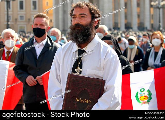 A man holds the Bible in his hand in St. Peter's Square during the Angelus prayer recited by Pope Francis. Vatican City (Vatican), February 28th, 2021