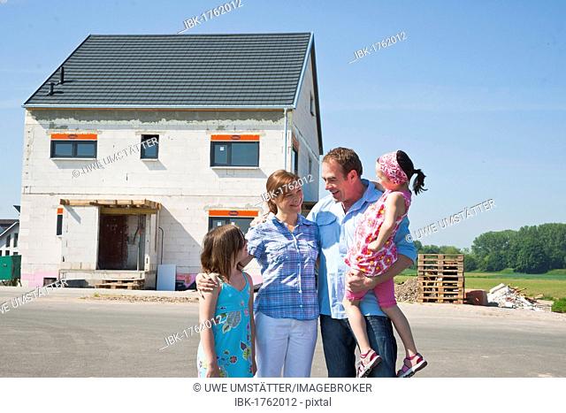 Family standing in front of their new home