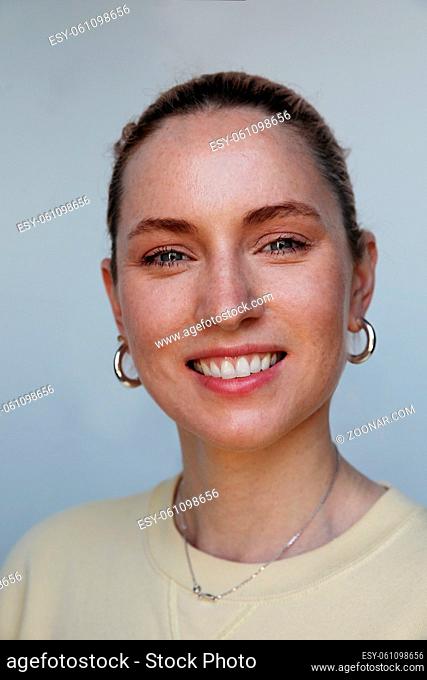Vertical portrait of a young happy woman smiling on white background, skin care and health. High quality photo