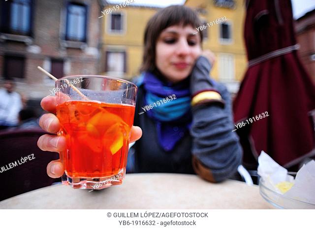 A young woman drinking an Aperol Spritz in Venice, Italy