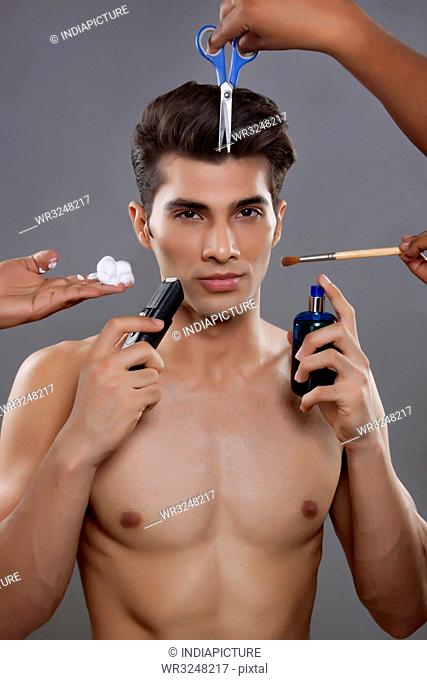 Portrait of young man with grooming equipment