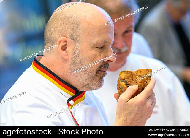 27 November 2023, Saxony-Anhalt, Magdeburg: Siegfried Brenneis from the German Bread Institute smells a stollen during the public stollen test