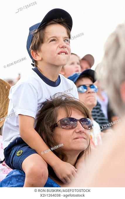 Young boy on mom's shoulders watches the skys during air show at NAS Jacksonville, Florida