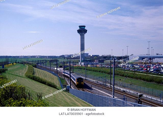 The rail link and control tower at Stansted Airport. Buildings and cars