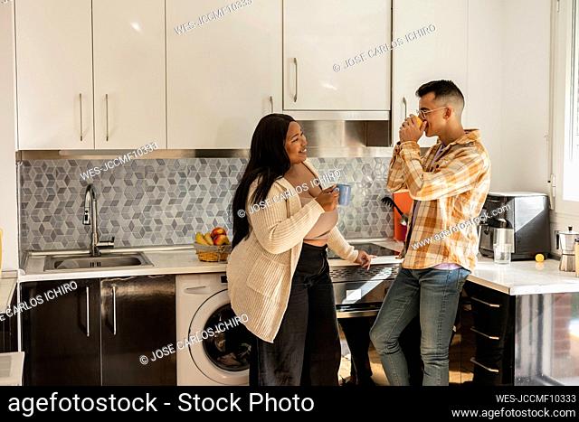 Couple enjoying coffee and spending leisure time in kitchen