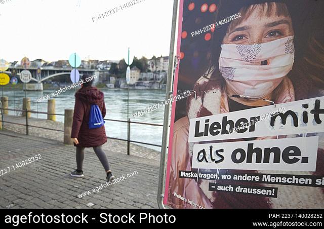 Basel, Switzerland - February 19, 2021: Spring Atmosphere despite Coronavirus. People are strolling outside and wearing Masks