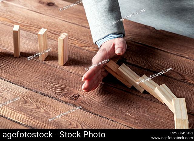 Business woman hand stop domino effect. Operative business solution, strategy and successful intervention. Life insurance company presentation with wooden...